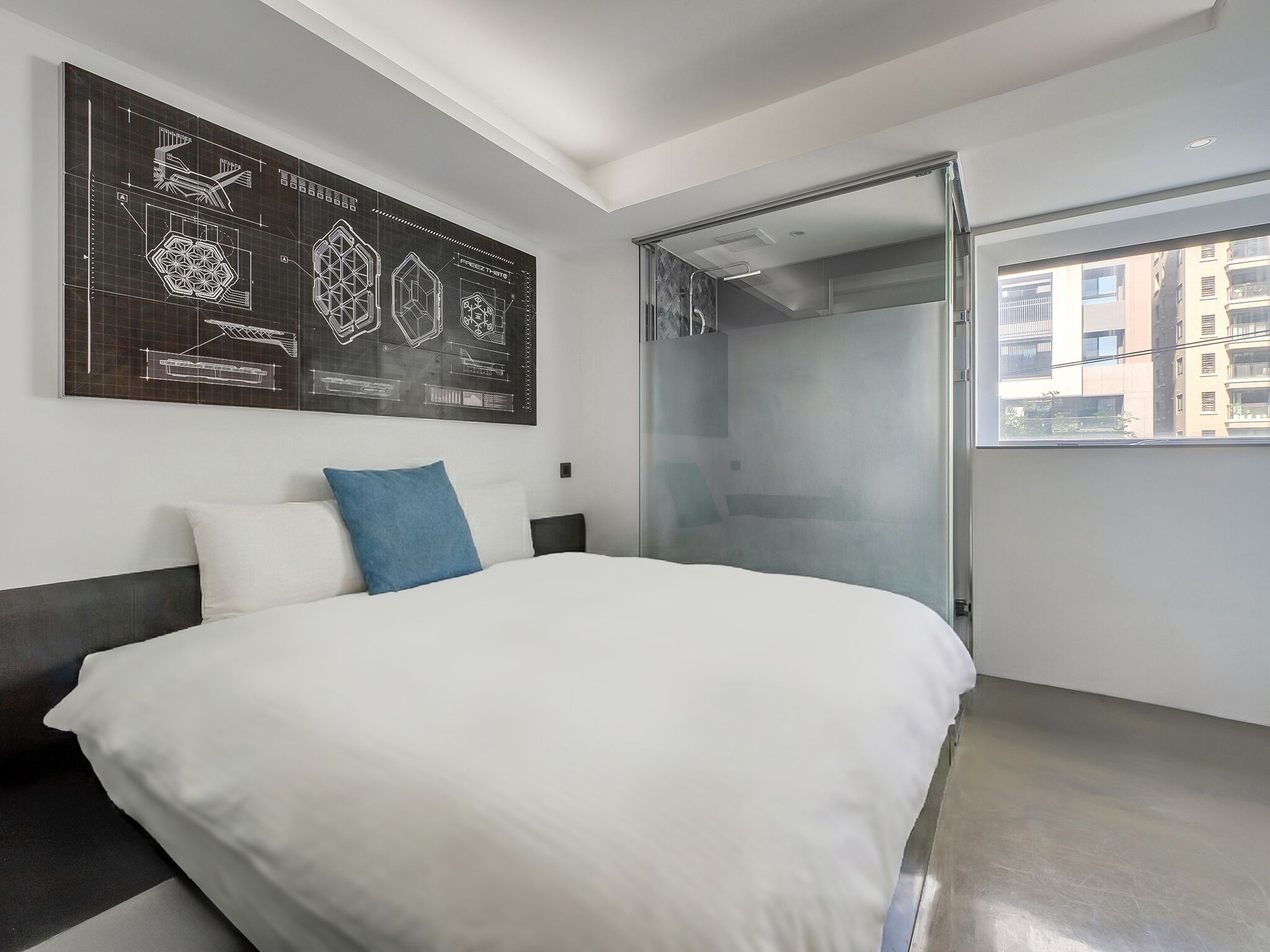 A modern hotel room with a large bed, a glass shower enclosure, and a city view.