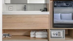 A modern bathroom with a white sink, mirror, and wooden vanity. - CHECK inn Taichung Liming (Taichung)
