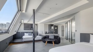 A modern hotel room with a large bed, a sofa, a desk, and a balcony with a city view. - CHECK inn Taichung Liming (Taichung)