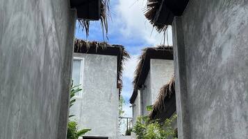 A concrete staircase leading to a building with thatched roofs.