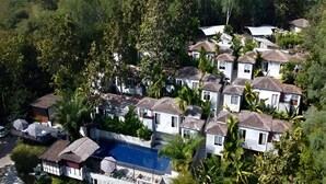 Un quartier résidentiel comprenant plusieurs maisons, une piscine et une végétation luxuriante.