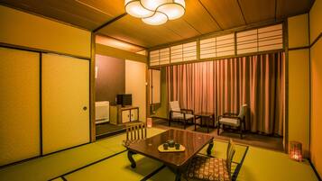 A traditional Japanese-style room with tatami flooring, a low table with a tea set, and sliding doors.