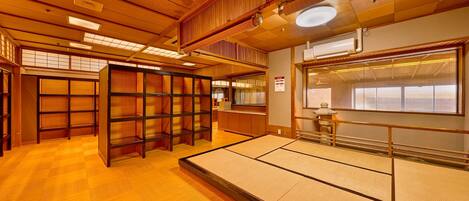 Een traditionele Japanse kamer met tatami vloeren, houten schuifdeuren en een uitzicht door een groot raam.