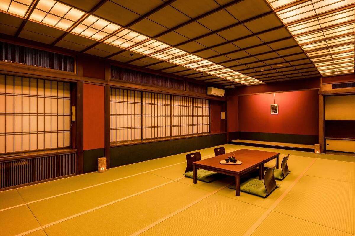 A traditional Japanese room with tatami flooring, a low table, and shoji screens.