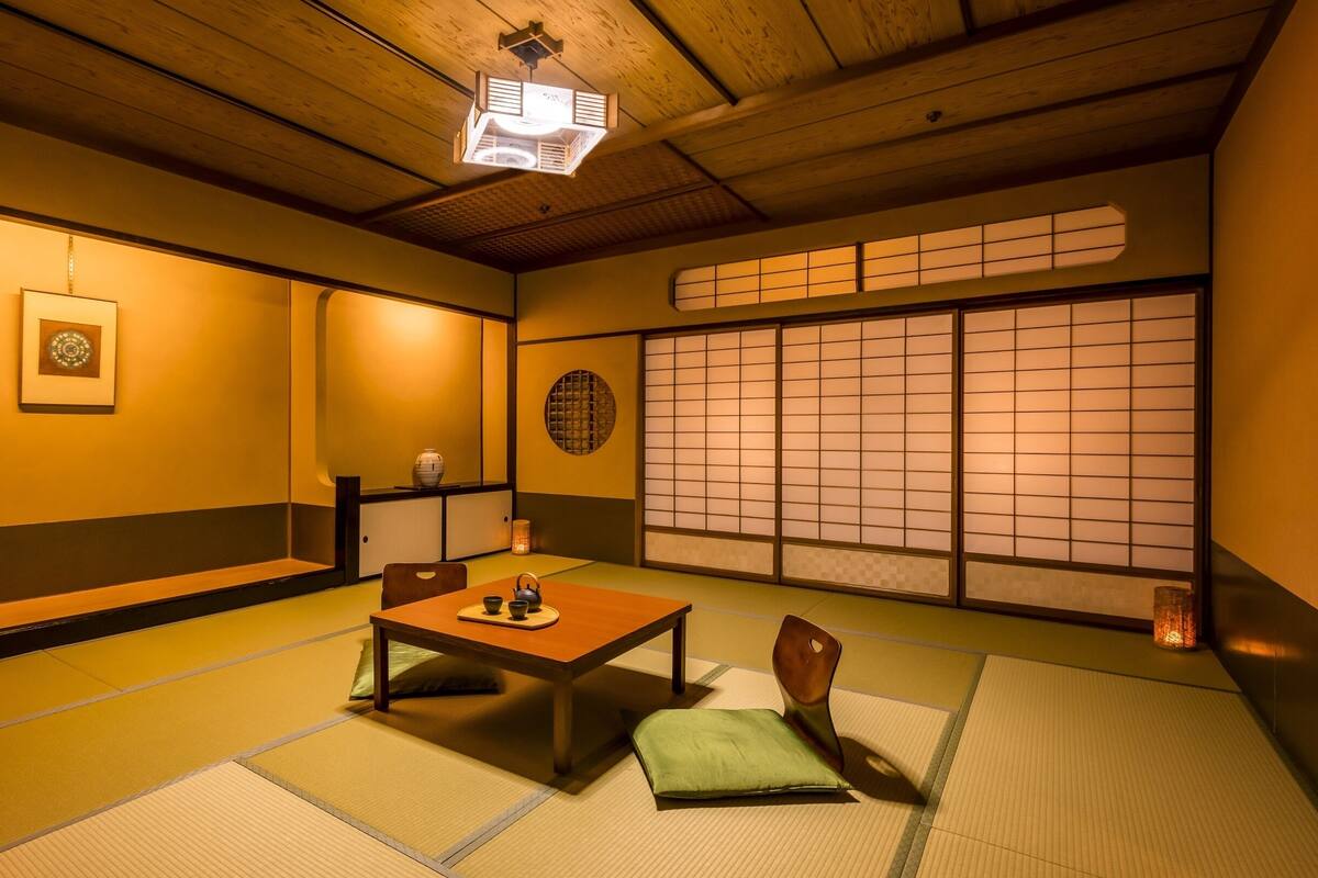 A traditional Japanese room with tatami flooring, a low table, and sliding doors.