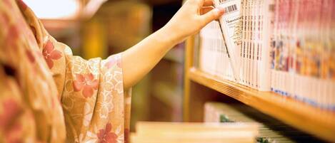 A person browsing books on a shelf in a library.