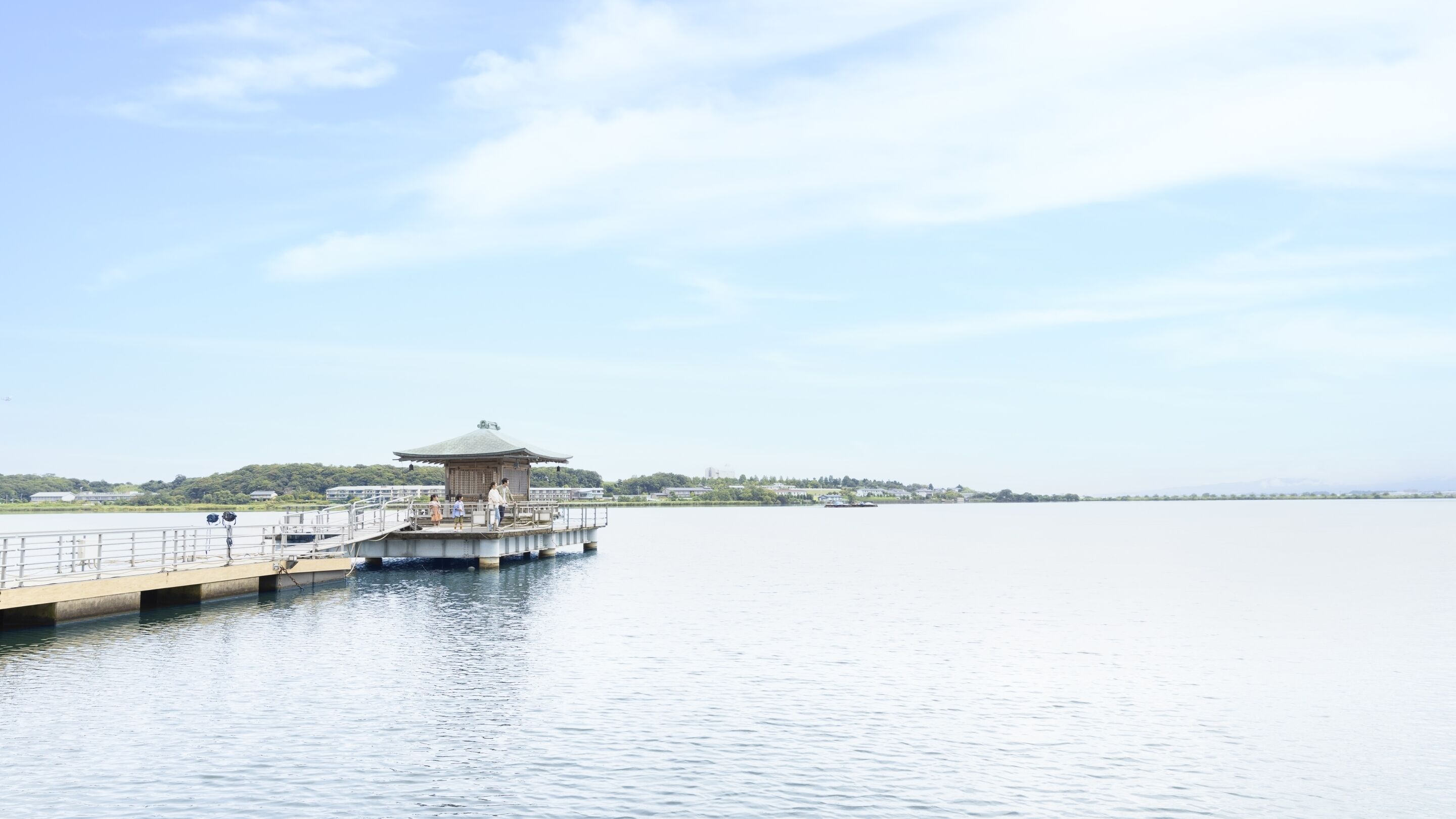 A pier extending into calm water with a traditional pavilion at the end.