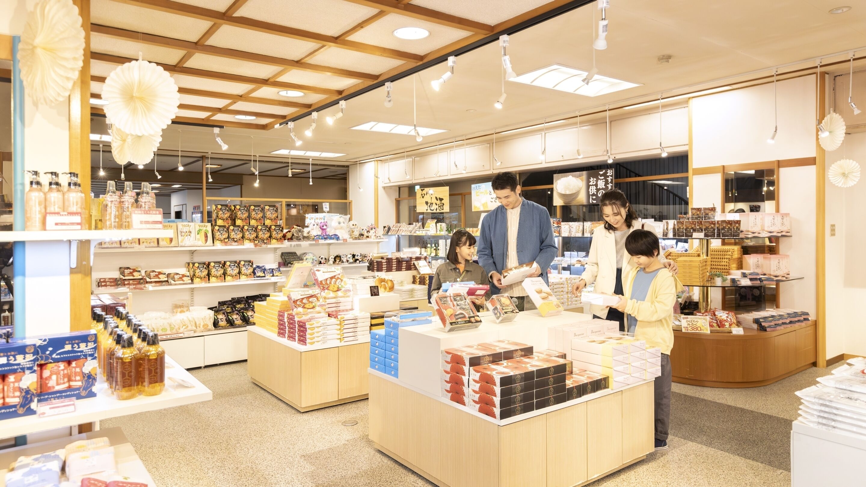 A well-lit store with wooden beams, shelves stocked with various products, and a counter where customers are interacting with staff.
