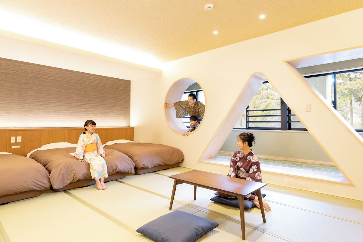 Ein traditioneller japanischer Raum mit Tatami-Böden, einem niedrigen Tisch und einer Couch.