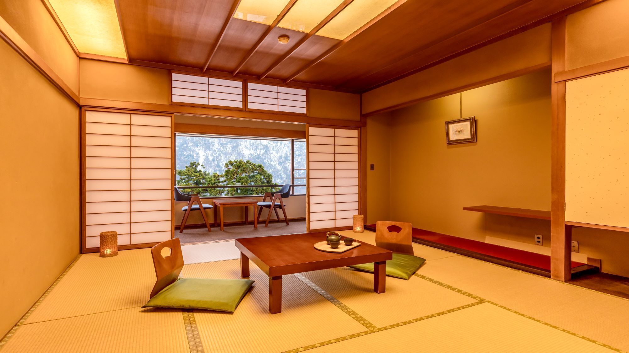 A traditional Japanese room with tatami flooring, a low table with a tea set, and sliding doors.