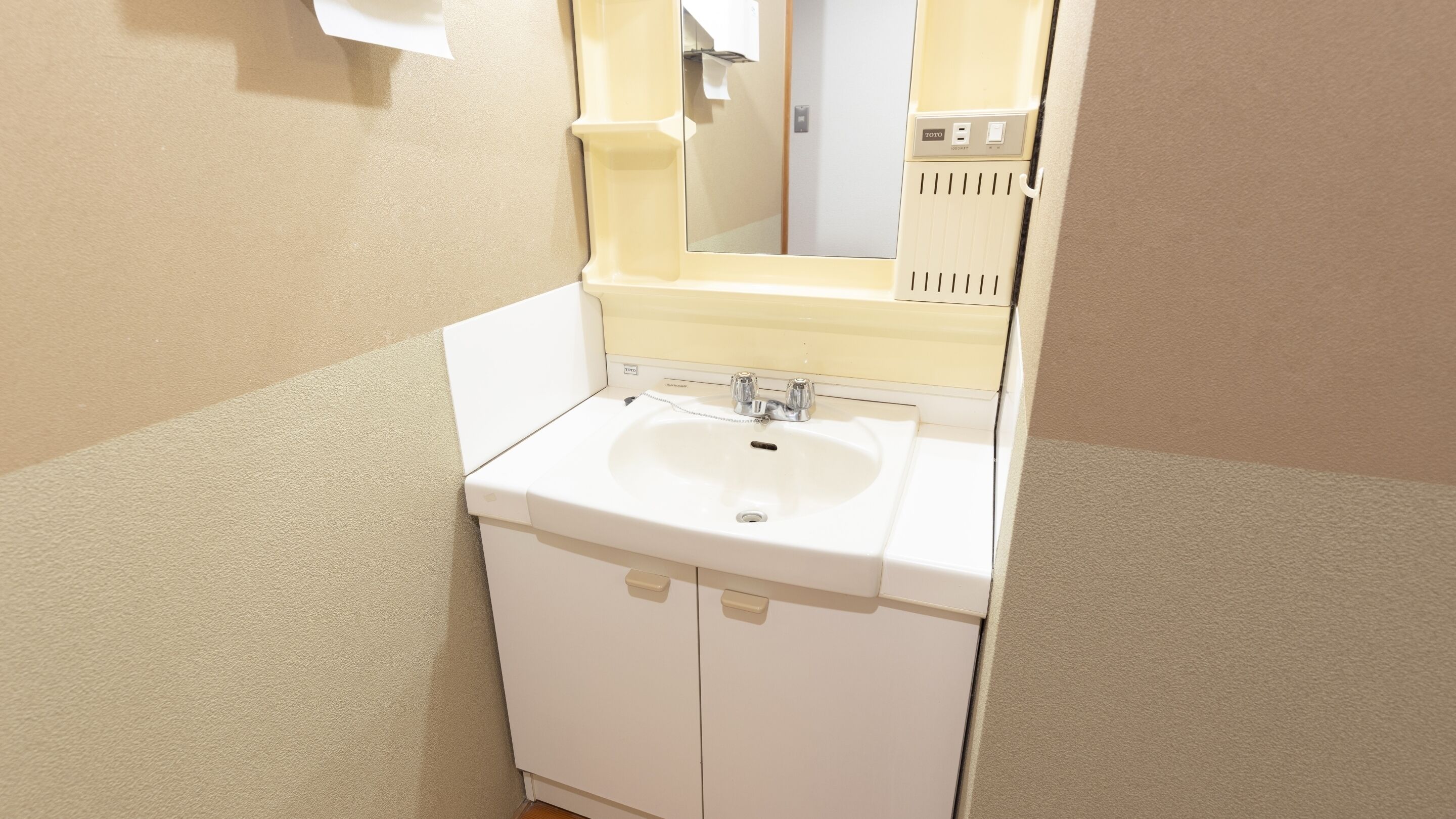 A bathroom with a white sink, mirror, and cabinet.