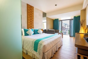 A hotel room with a bed, a desk, a chair, a view of the outside, and a window with curtains.