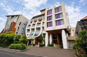 Un hotel moderno con un diseño arquitectónico único, que cuenta con un atrio central con techo de vidrio y varios balcones.