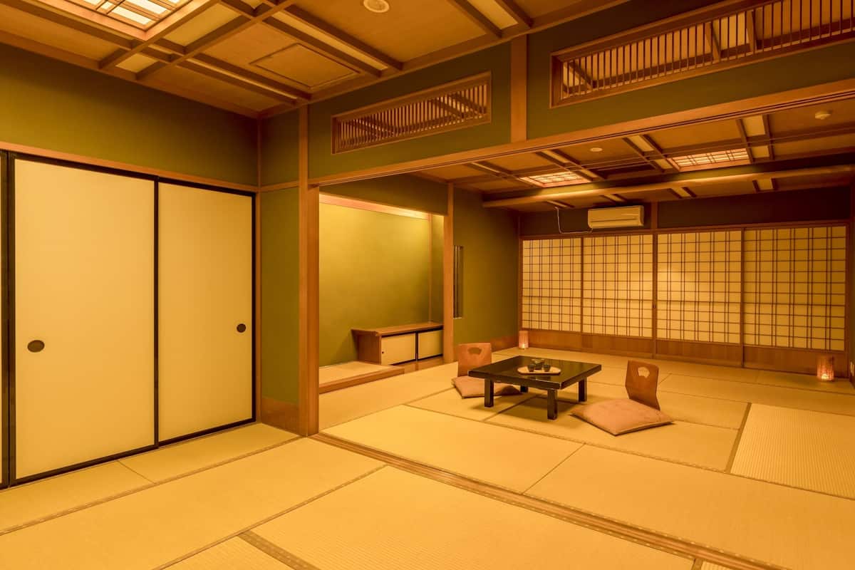 A traditional Japanese room with tatami flooring, sliding doors, a low table with cups, and a shoji screen.