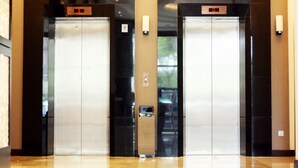 Two elevator doors with a digital display above each, set in a modern lobby with a polished floor. - Geobay Hotel (Johor Bahru)