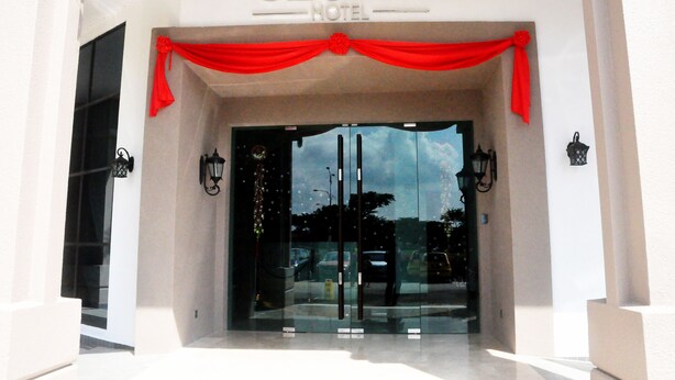 The entrance of the GeBay Hotel with a red draped entrance and glass doors. - Geobay Hotel (Johor Bahru)