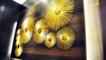 A wall with a series of golden, sunburst-shaped light fixtures.