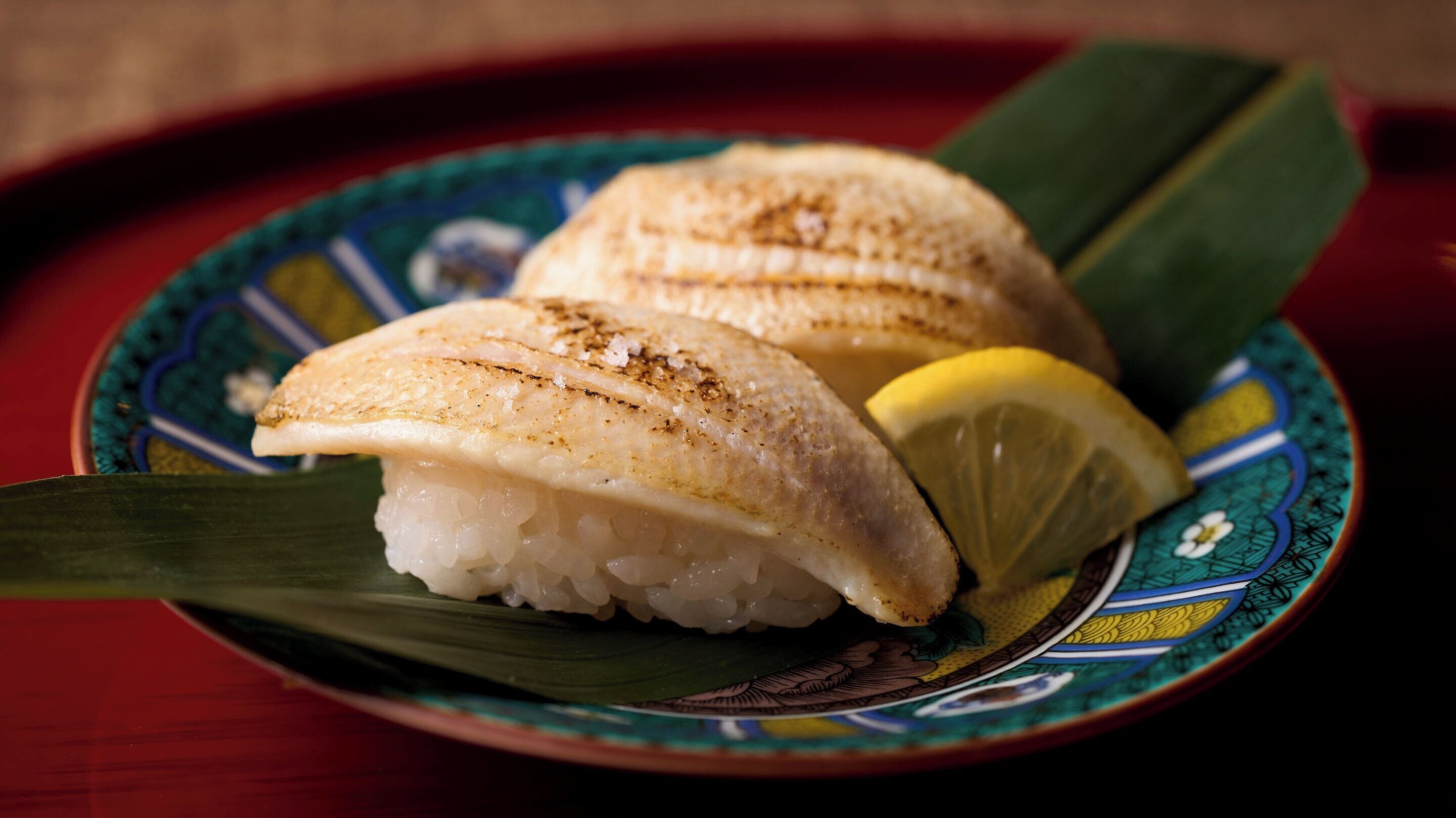 Prato com prato de peixe e uma fatia de limão.