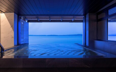 A spa area with a view of a calm body of water and distant hills.