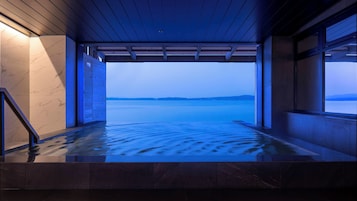 Un área de spa con vistas a un cuerpo de agua tranquilo y colinas al lejano.