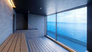 Un interior moderno con cubierta de madera, zona de estar y un ventanal con vista a un cuerpo de agua.