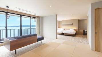 Une chambre d’hôtel moderne dotée d’un grand balcon, d’un canapé, d’un lit avec deux oreillers et d’un bureau.