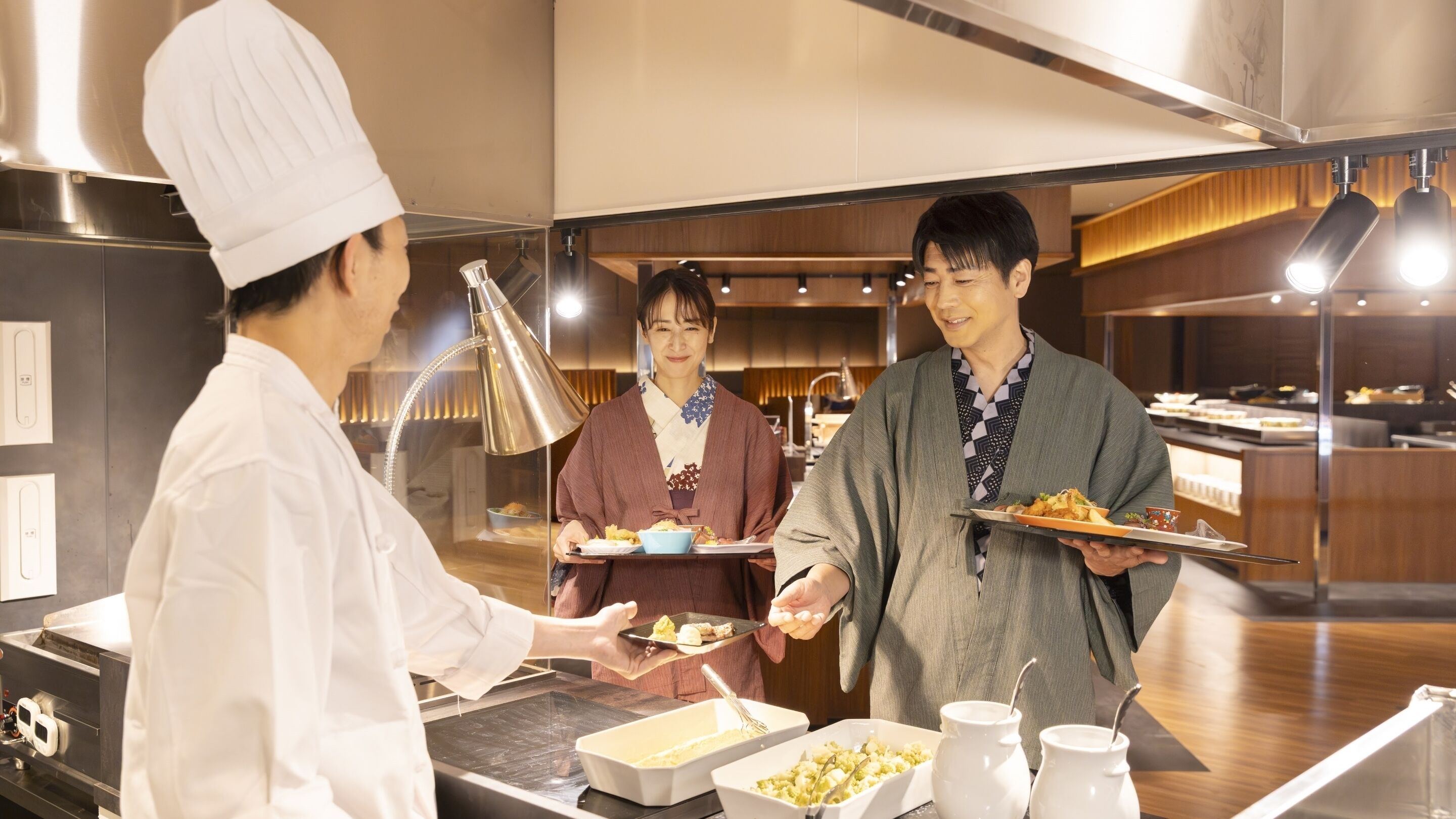 Een restaurantinterieur met een buffetopstelling, inclusief voedselbakken en bestek.