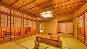 A traditional Japanese room with tatami flooring, a low wooden table, and sliding doors. - Ooedo Onsen Monogatari Wanwan Resort Awazu (Komatsu)