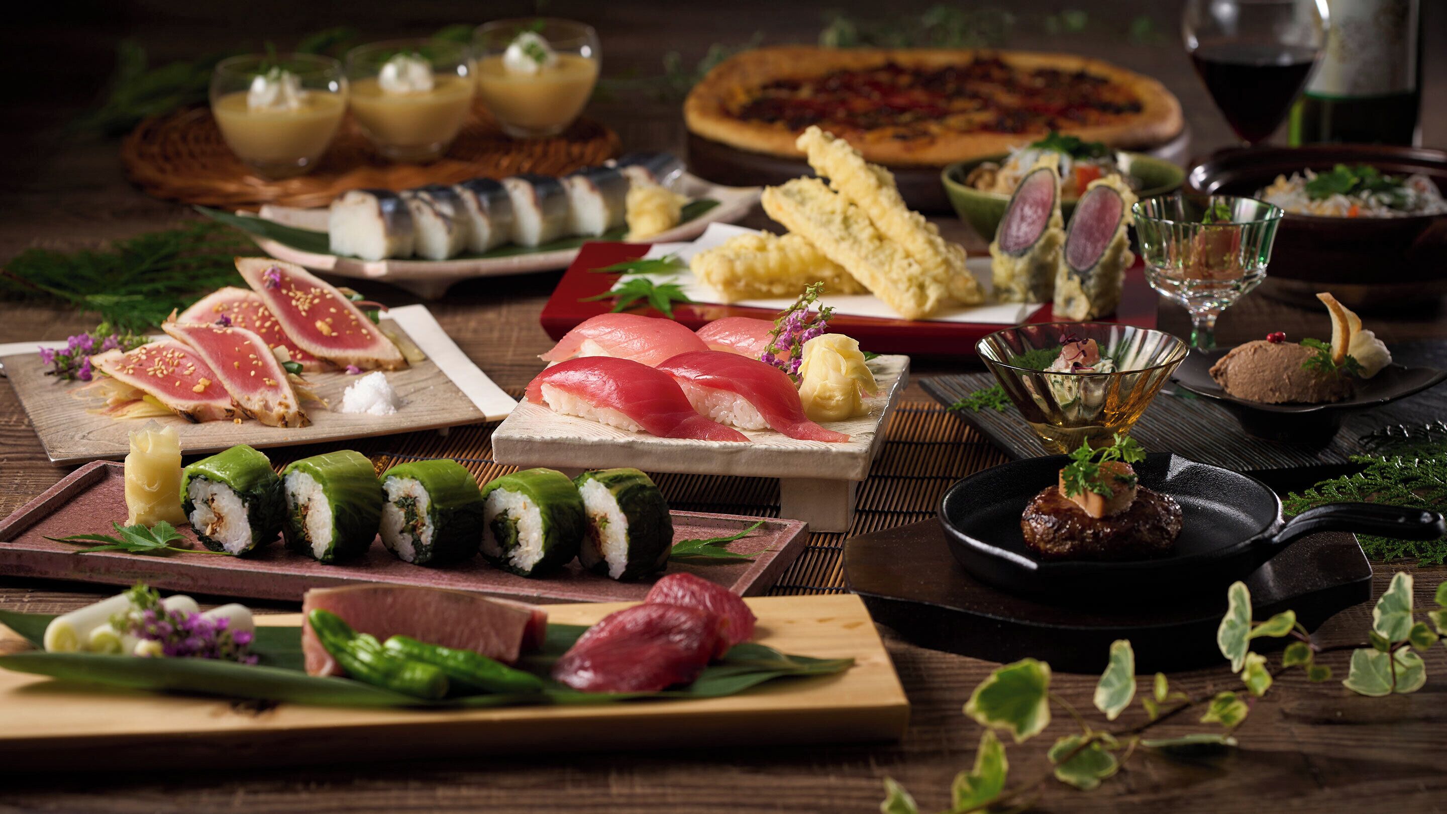 Variedad de platos de sushi y otra cocina japonesa sobre una mesa de madera.