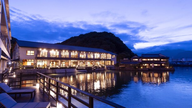 Un hotel frente al mar con varias habitaciones, una zona de piscina y una terraza para comer.