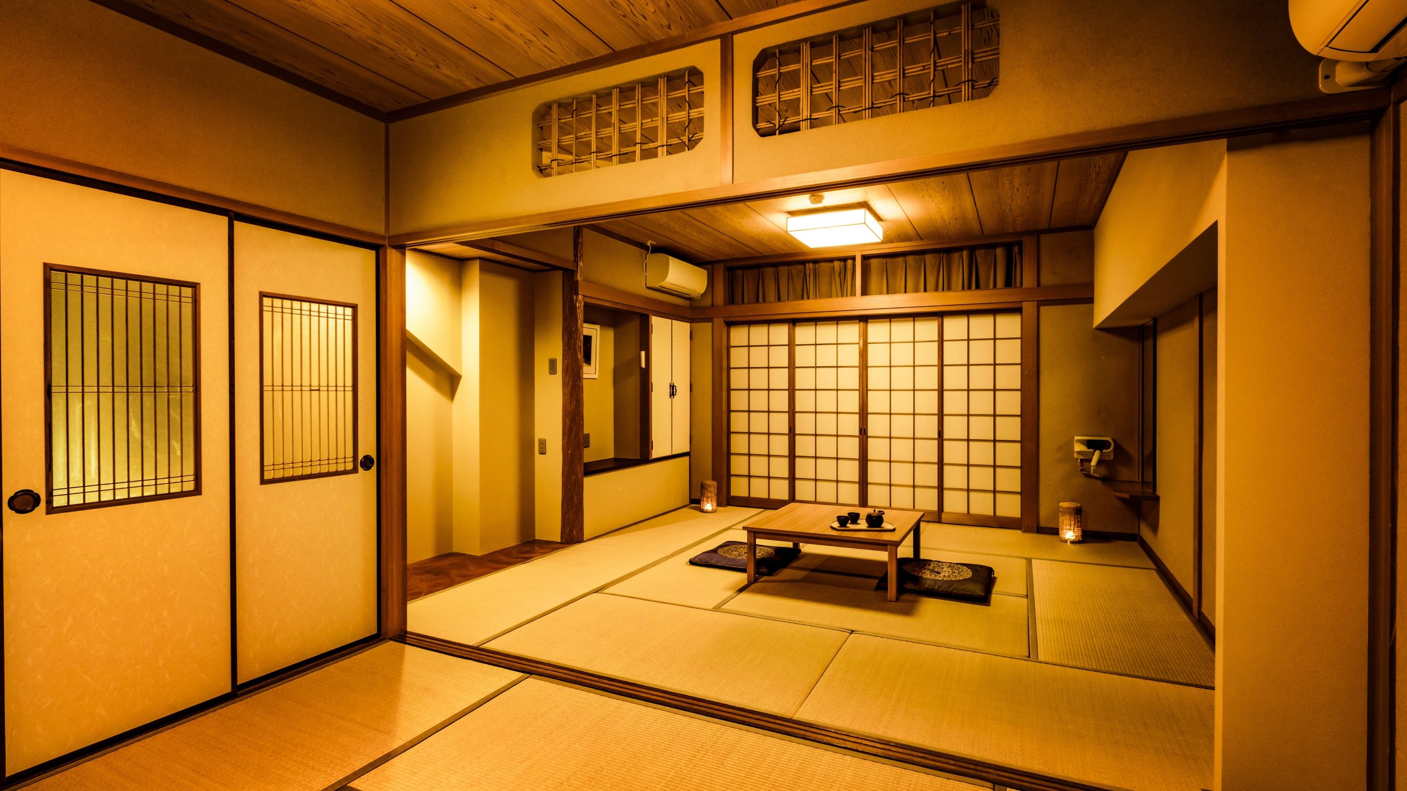 A traditional Japanese room with tatami flooring, sliding doors, and a low table with tea set.