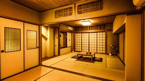 Een traditionele Japanse kamer met tatami vloerbedekking, schuifdeuren en een lage tafel met theeservies.