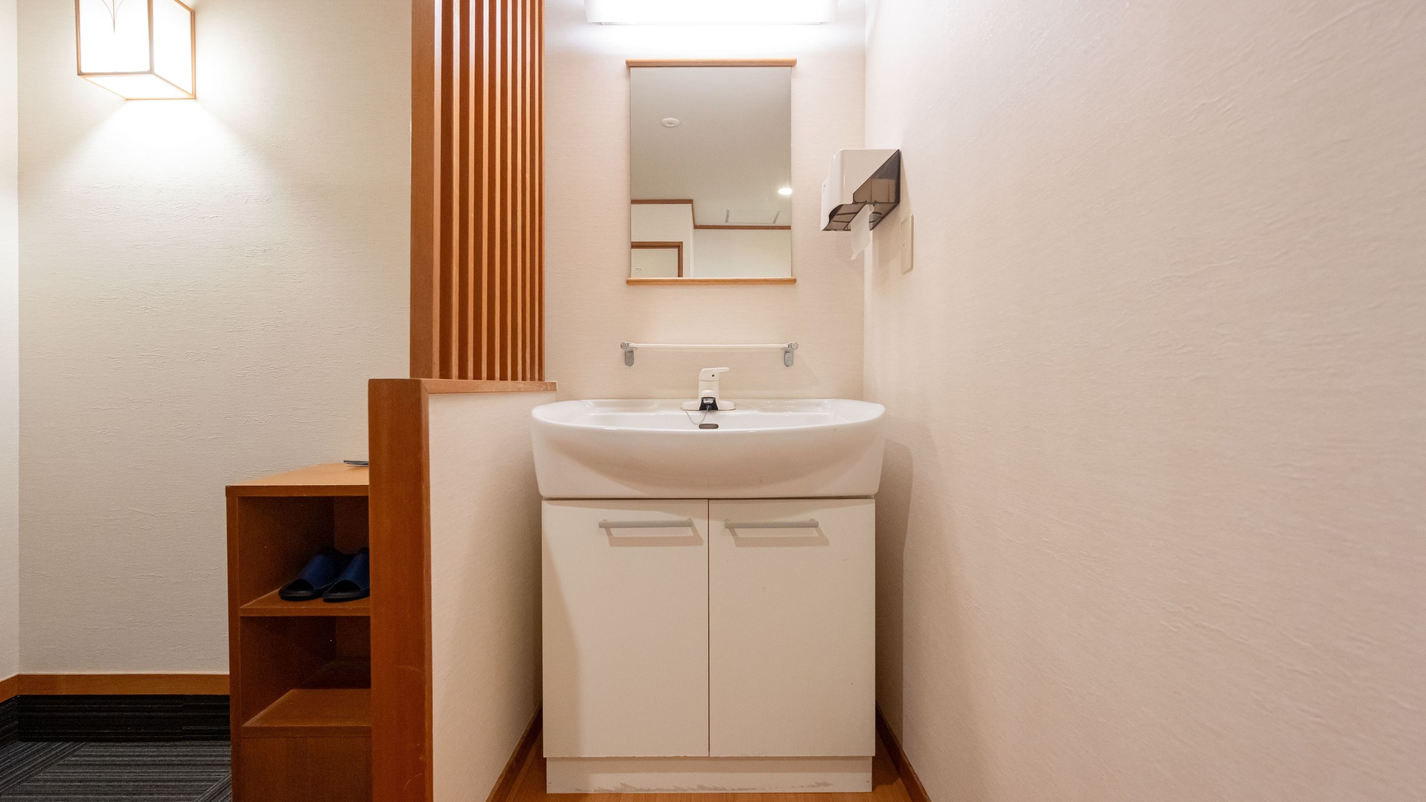 Een badkamer met een wastafel, spiegel en een houten plank.