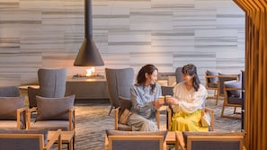Un área de estar moderna con asientos y chimenea.
