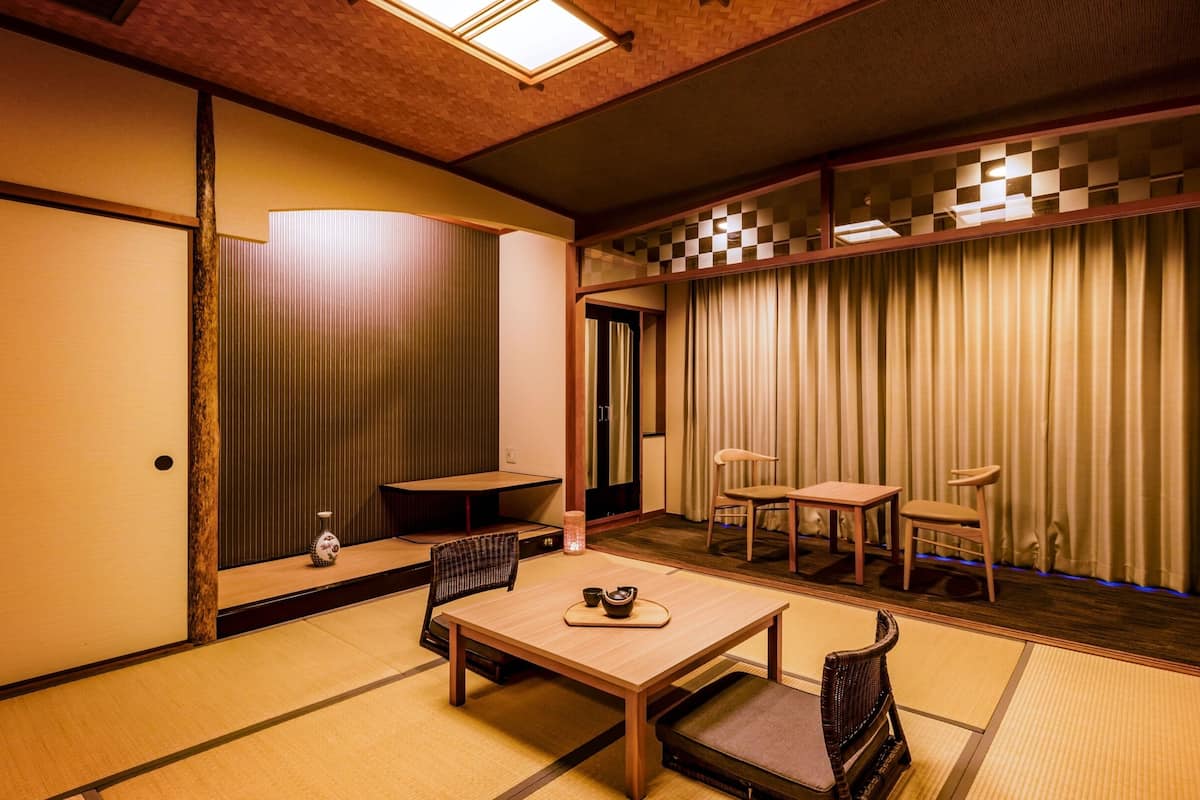 Een traditionele Japanse kamer met tatami vloeren, een lage tafel met een theeset en schuifdeuren.