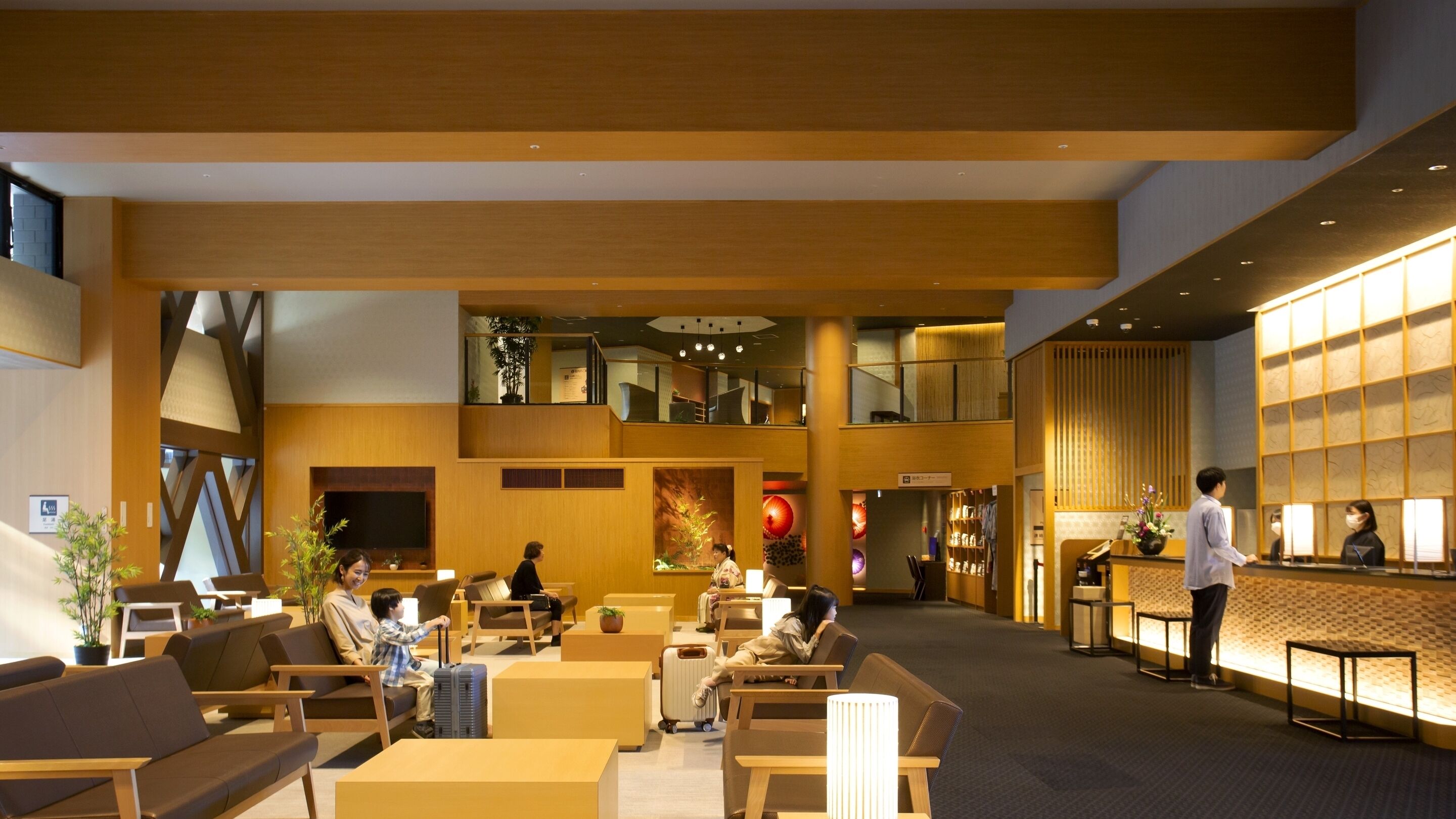 A spacious lobby with seating areas, a reception desk, and a staircase leading to an upper level.
