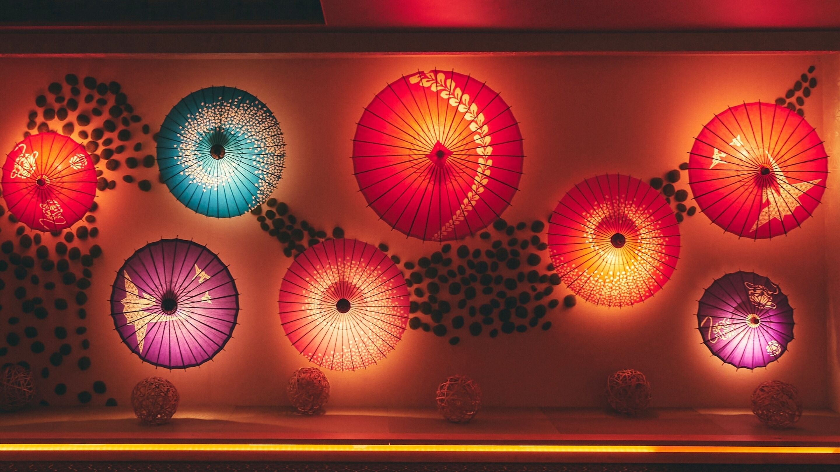 A display of variously colored umbrellas arranged in a row.