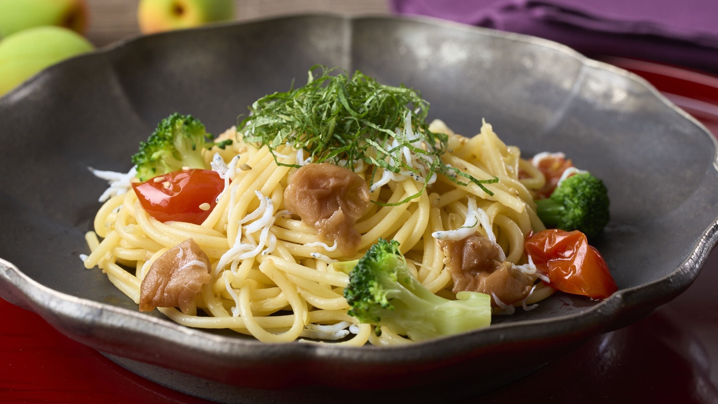 Een kom pasta met broccoli en cherrytomaatjes.