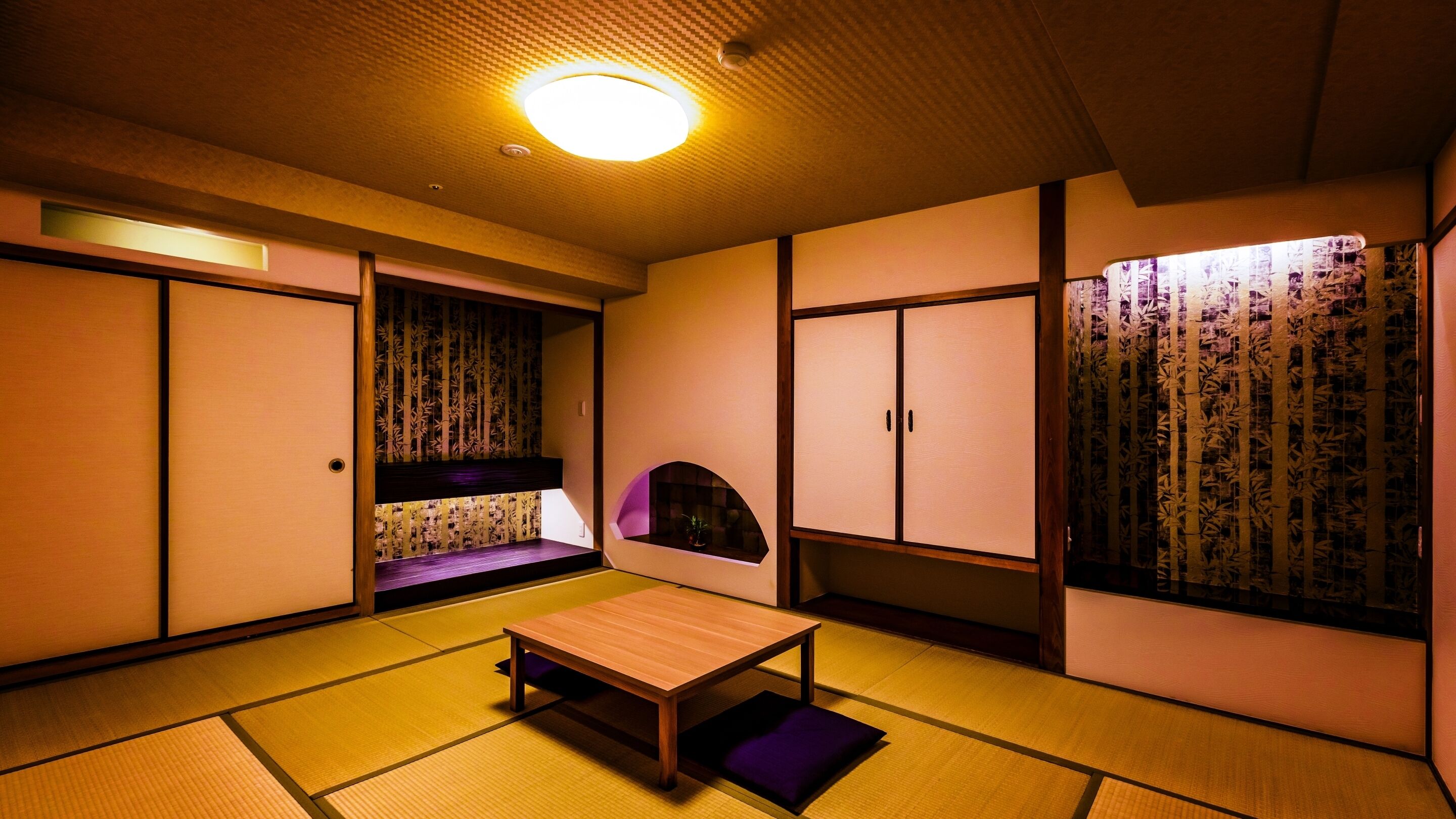 A traditional Japanese room with tatami flooring, sliding doors, and a low table.