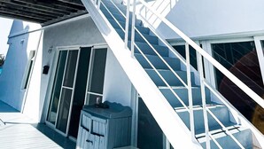 Una escalera blanca que conduce a una terraza con vistas al cielo.