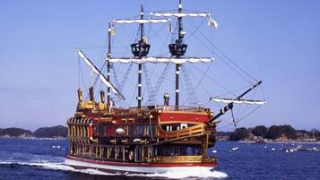 A large, ornate ship with multiple decks and a prominent mast, sailing on a body of water.