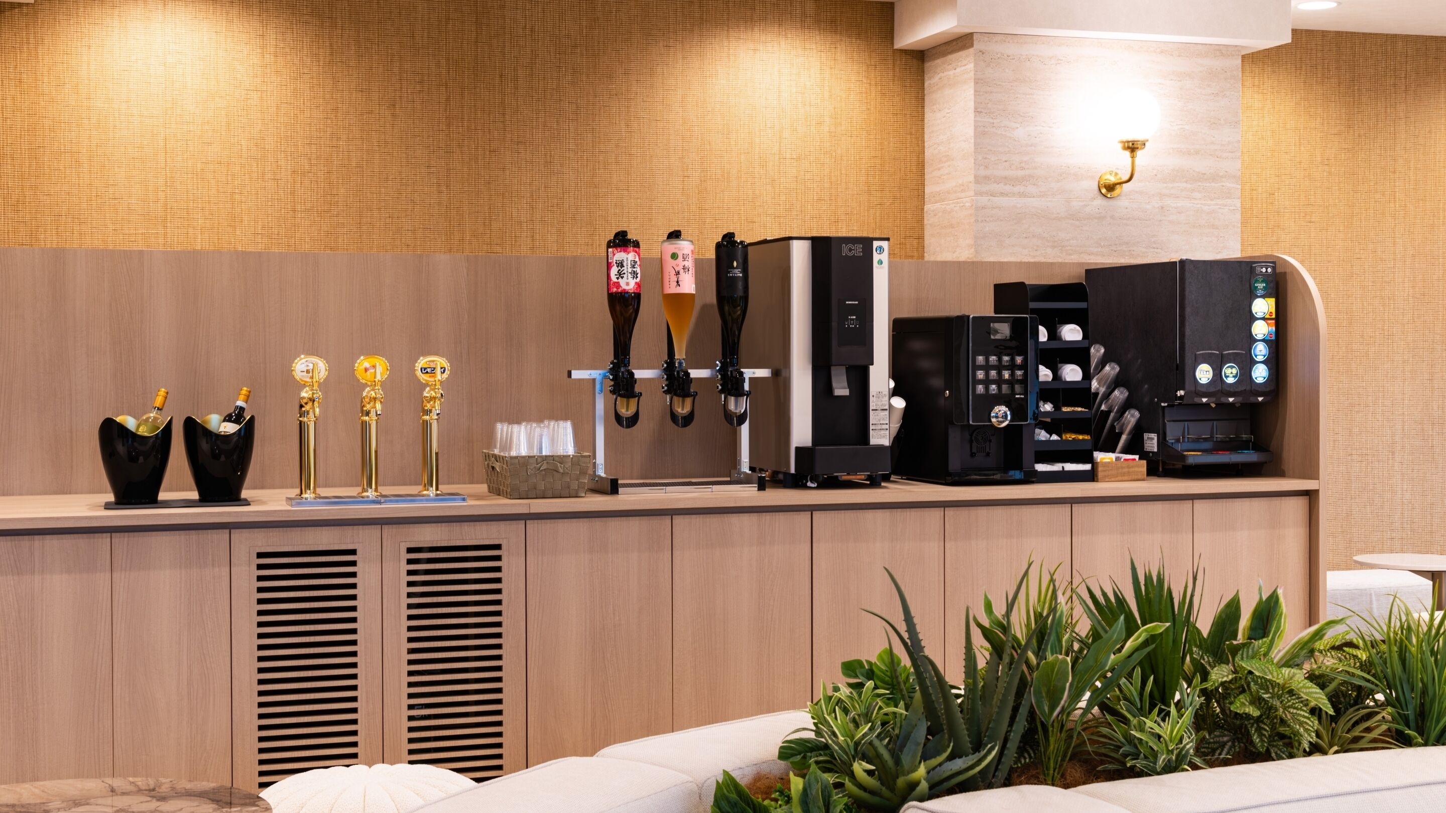 A modern bar area with multiple beer taps, a coffee machine, and a wine bottle display.