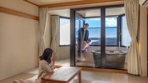 A modern room with a large sliding glass door leading to a balcony with a view of the sea. - Ooedo Onsen Monogatari Premium Shima Saichoraku (Shima)