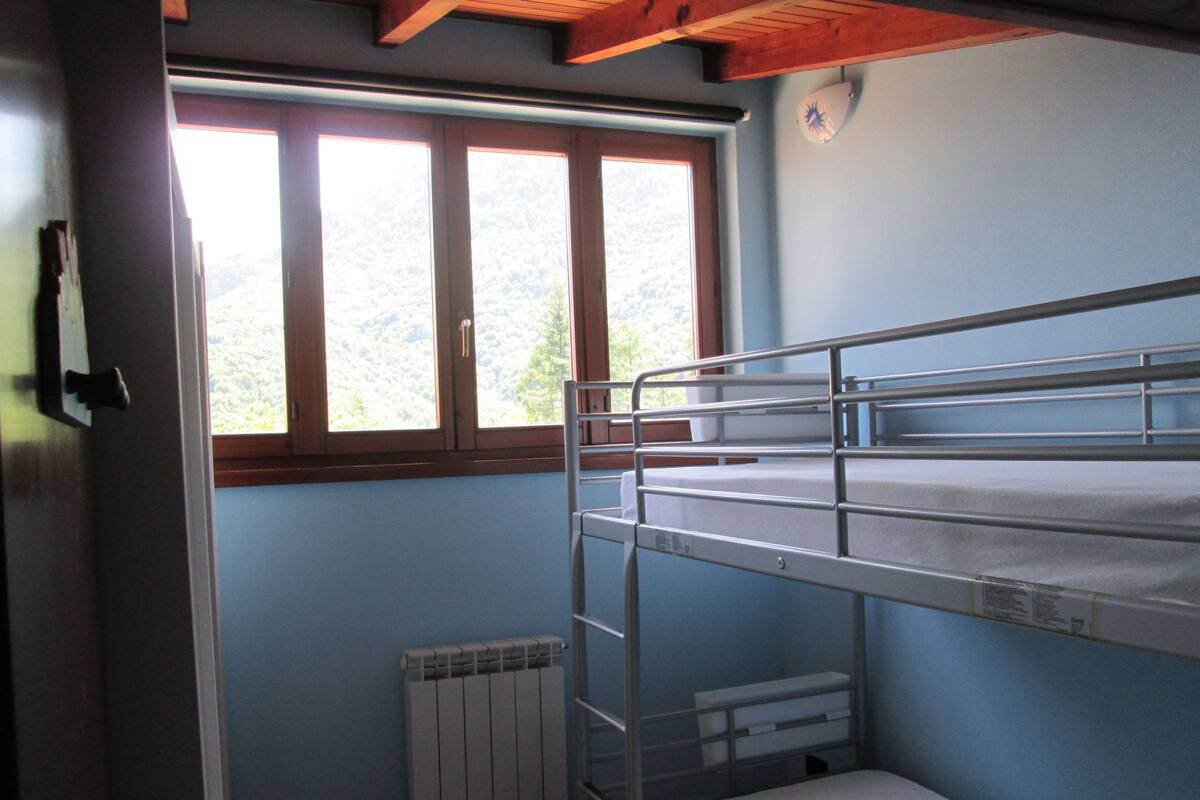 A bunk bed room with a window and radiator.