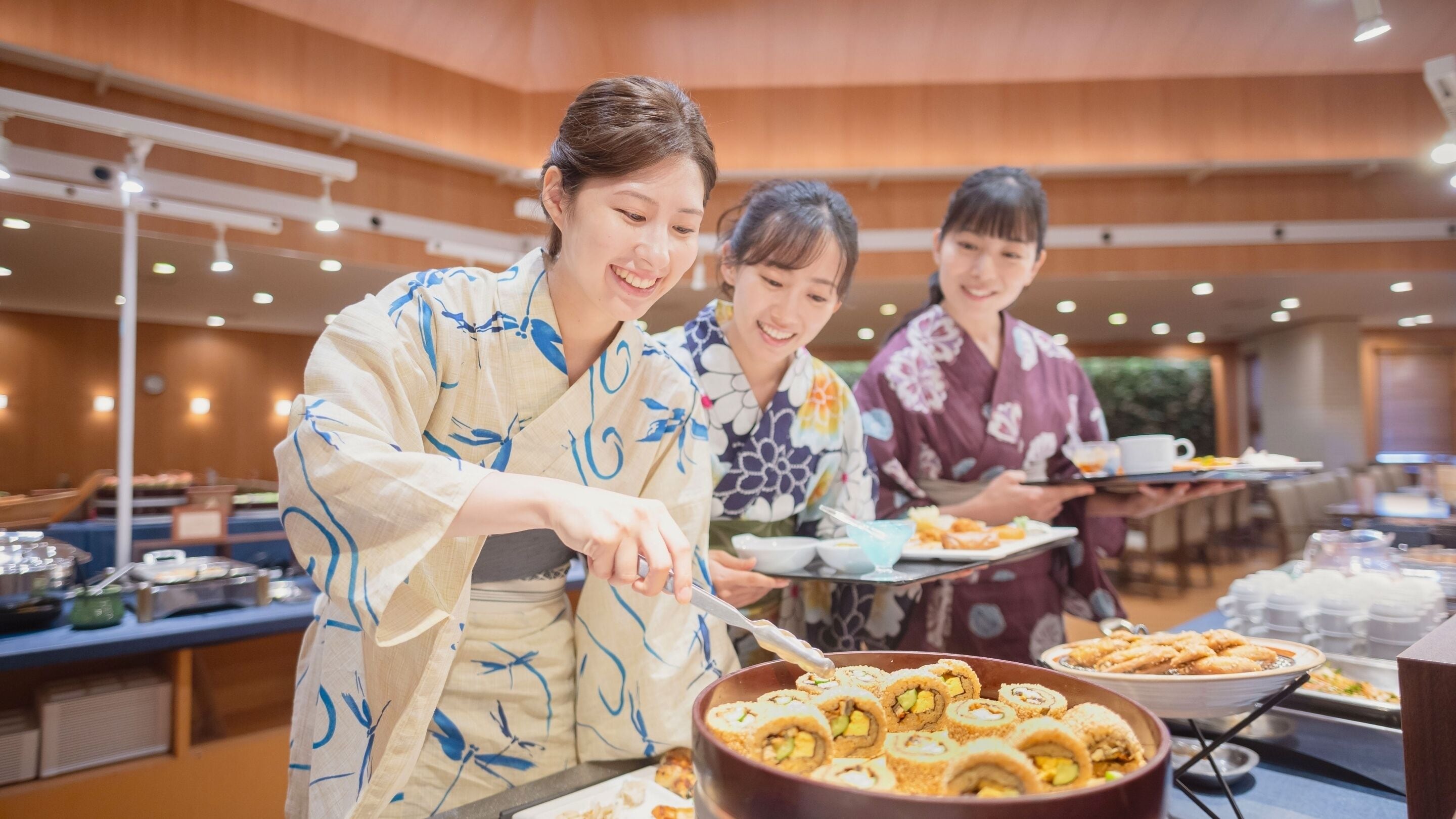 A buffet setup with food items and people serving.