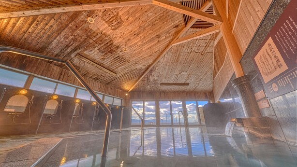 A wooden interior with a glass pool, metal railings, and a view of the sky. - Ooedo Onsen Monogatari Dogo (Matsuyama)