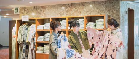 A store with shelves of folded textiles and a sign indicating a viewing area.