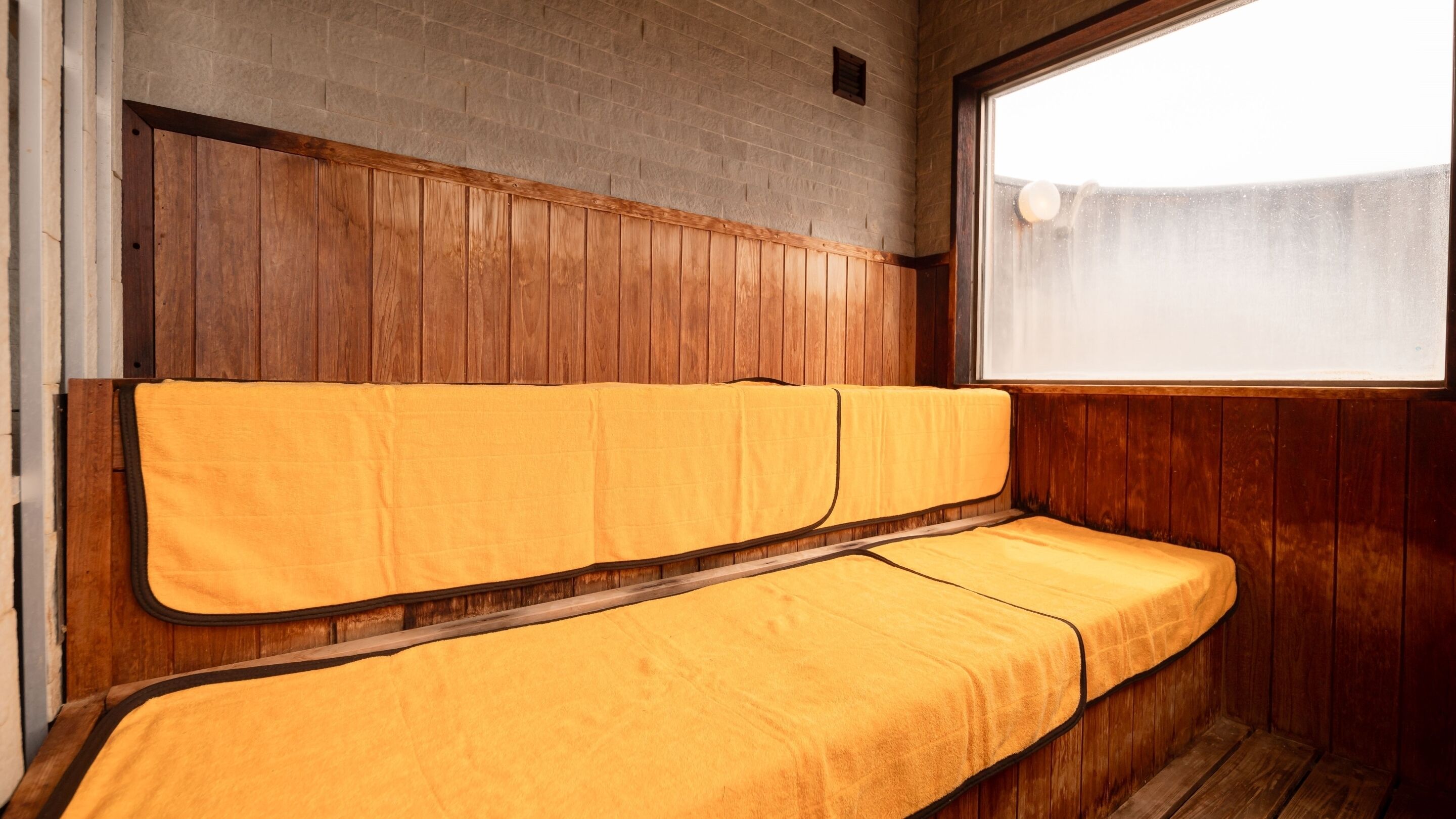 A room with a wooden bench and a window.