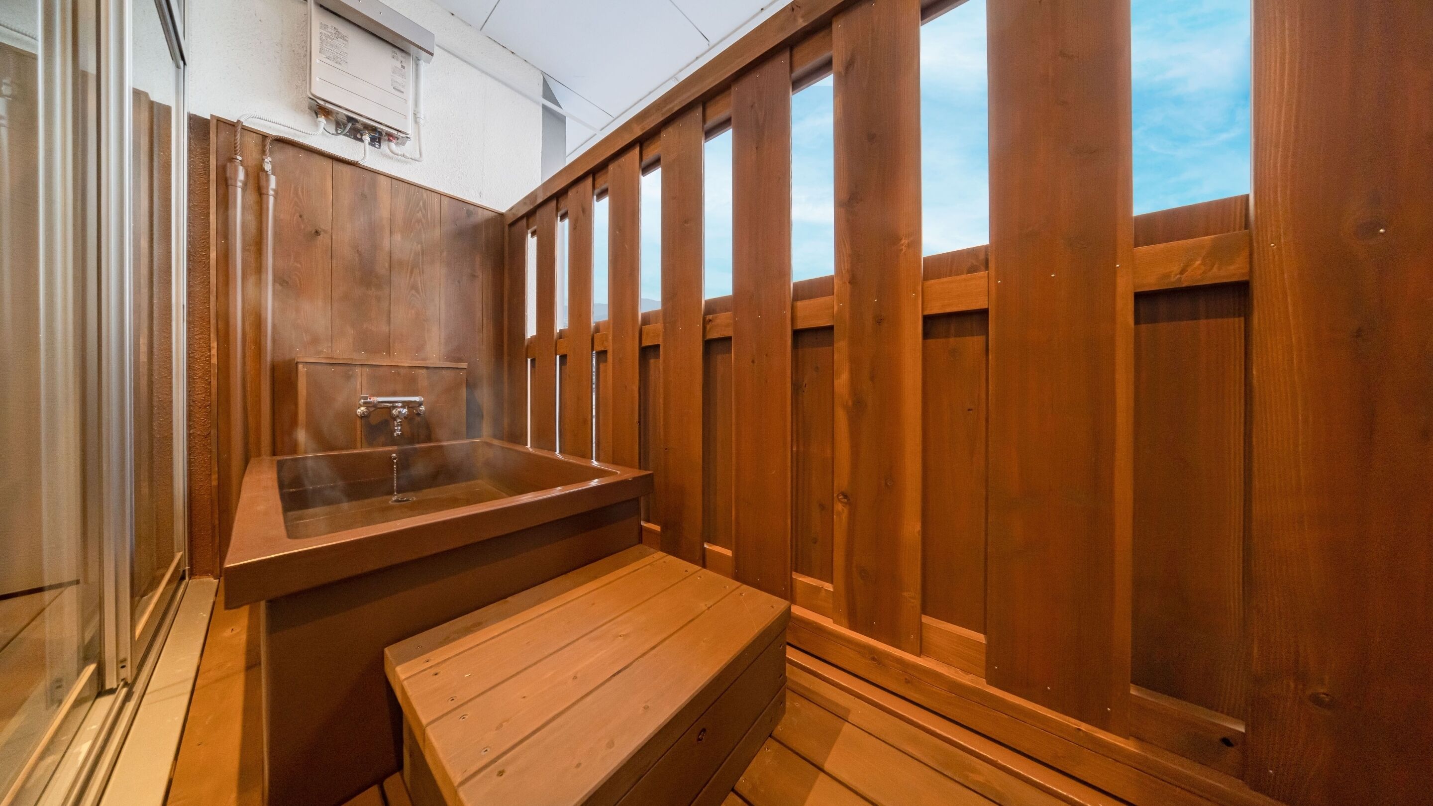 Eine Holzsauna mit Sitzbank, einer Holzwand und einem Fenster.