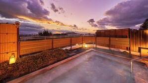A rooftop terrace with a pool, wooden fences, and ambient lighting. - Ooedo Onsen Monogatari Dogo (Matsuyama)
